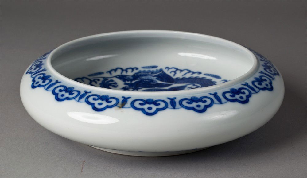 Chinese Qing Blue & White Dragon Bowl: Finely decorated to depict a five clawed dragon chasing a flaming pearl amongst ruyi clouds the recessed base with seal mark the Great Qing Qianlong Productions, 9.75"D X 2.5"H, circa 19th century.