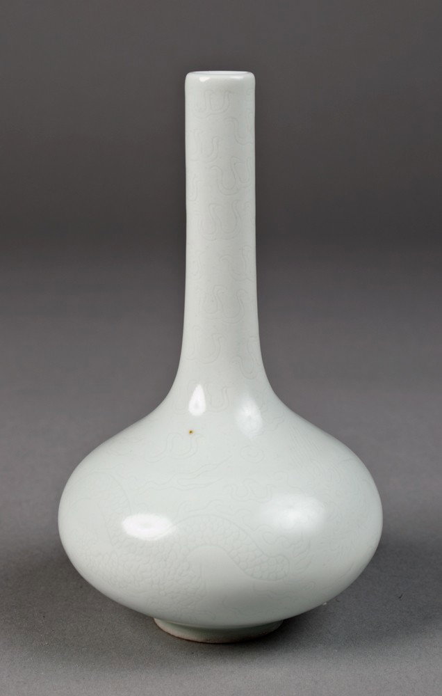 Chinese Molded Porcelain Vase: Long neck vase in white, finely molded to depict a dragon and flaming pearl. Six character mark within two concentric circles in underglaze blue on underside. 5 & 5/8" H, circa 20th century.