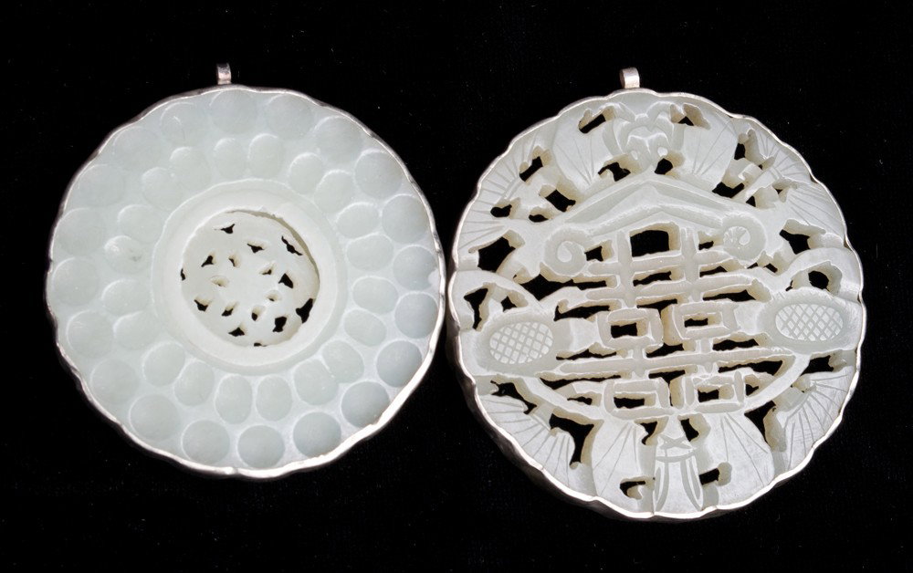 (2) Chinese Carved & Mounted Jade Plaques: The larger finely carved openwork depicting symbols and bats, the smaller with openwork carved moveable center. Largest 2.25" Dia., circa 20th century.