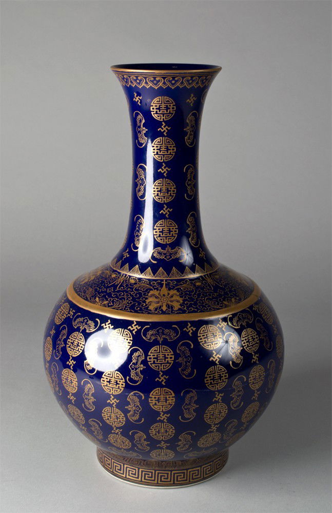 A Chinese Guangxu Gilt Decorated Porcelain Vase: A large bottle shaped vase finely decorated in gilt to depict bats shou symbols against a cobalt blue ground, the base with six character Guangxu mark within a rectangular gilt square to the base, 15.