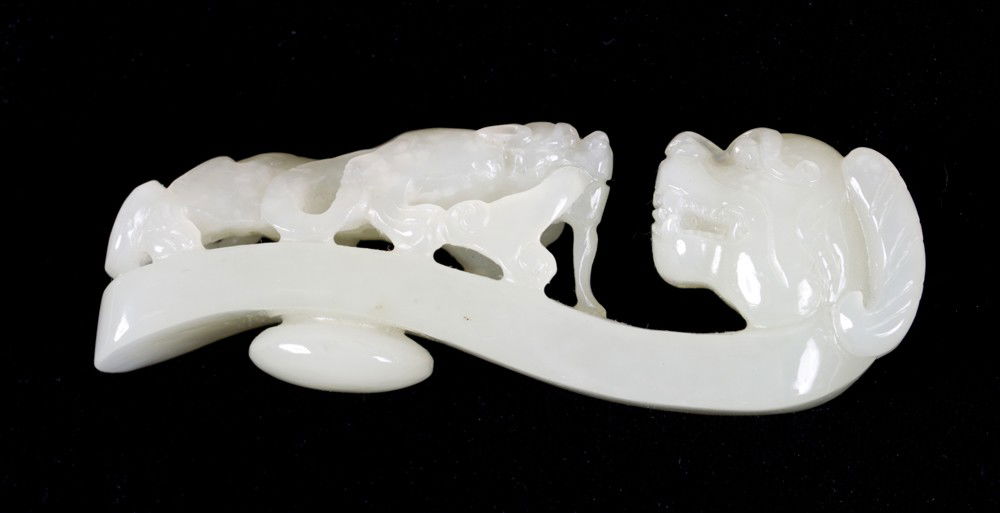 A Fine Chinese Carved White Jade Buckle: Finely carved to depict a dragon with chilong the stone with ax extremely good polish and nice curve, 3"L circa late 19th-early 20th century.