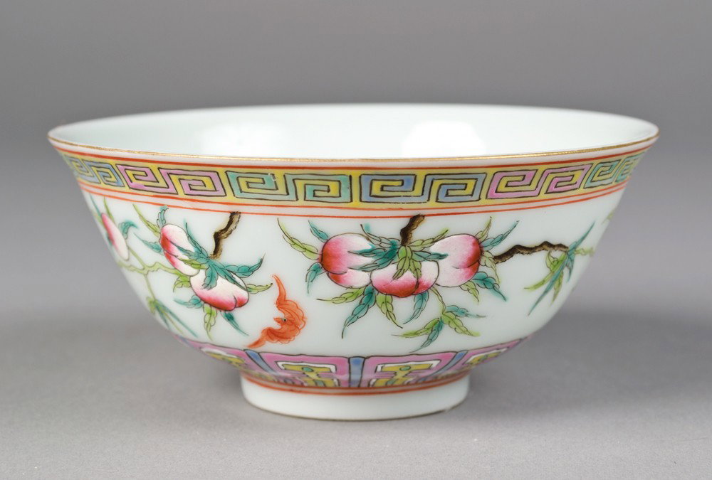 Chinese Famille Rose Porcelain Tea Bowl: Finely enameled to depict peaches and Greek key design with iron red bats. Six character mark for Great Qing Qianlong Production in iron red on underside. 2" H x 4.5" Dia., circa 20th century.