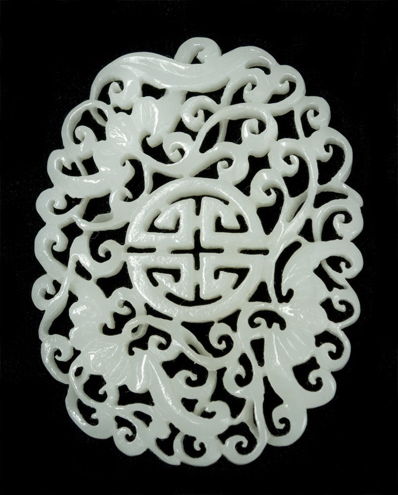 Chinese Qing Carved White Jade Plaque: Finely carved to depict bats surrounding shou symbol, the plaque with openwork carving, the stone a pure white with fine polish. 2.5" H x 1.75" W, circa late 19th century. Private collection Bloomfiel
