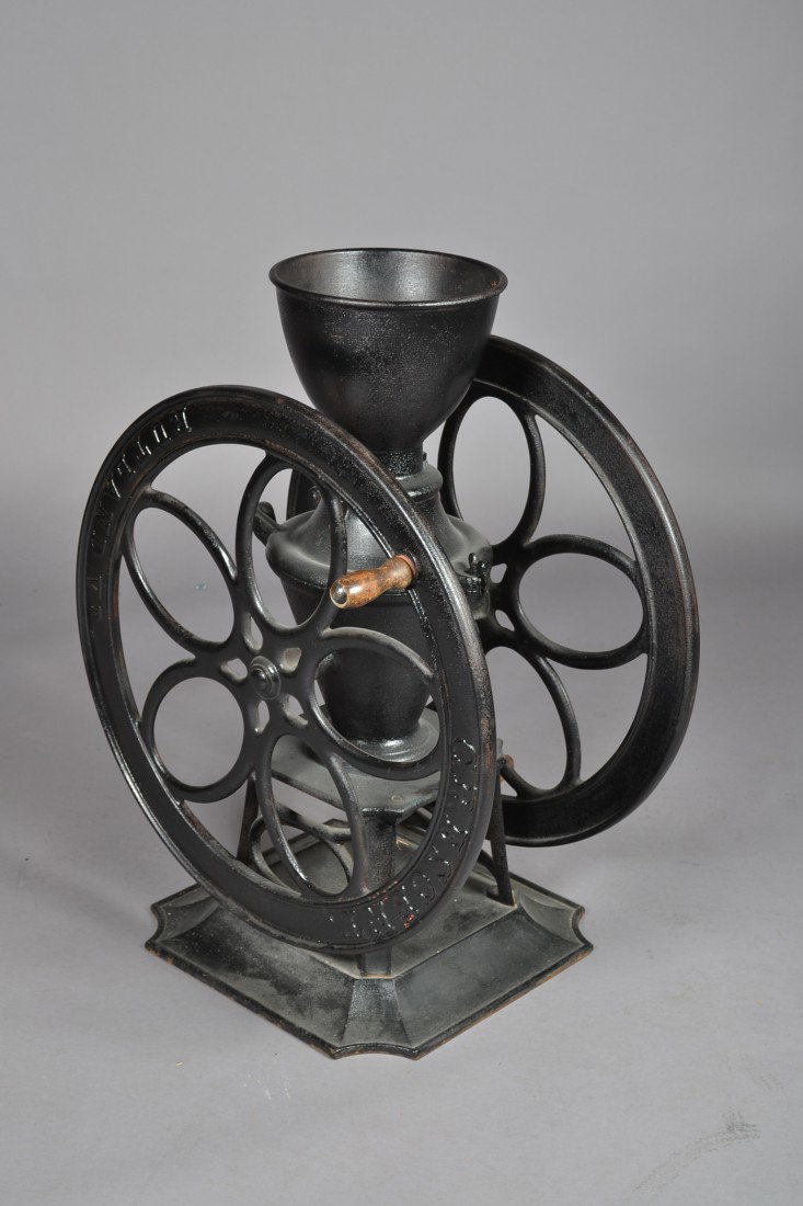 Rutland Vermont Cast Iron Coffee Grinder: A painted Crescent two wheeled cast iron coffee grinder with wooden knobs. Wheel is 25"D and Height is 32"H. Very nice condition.