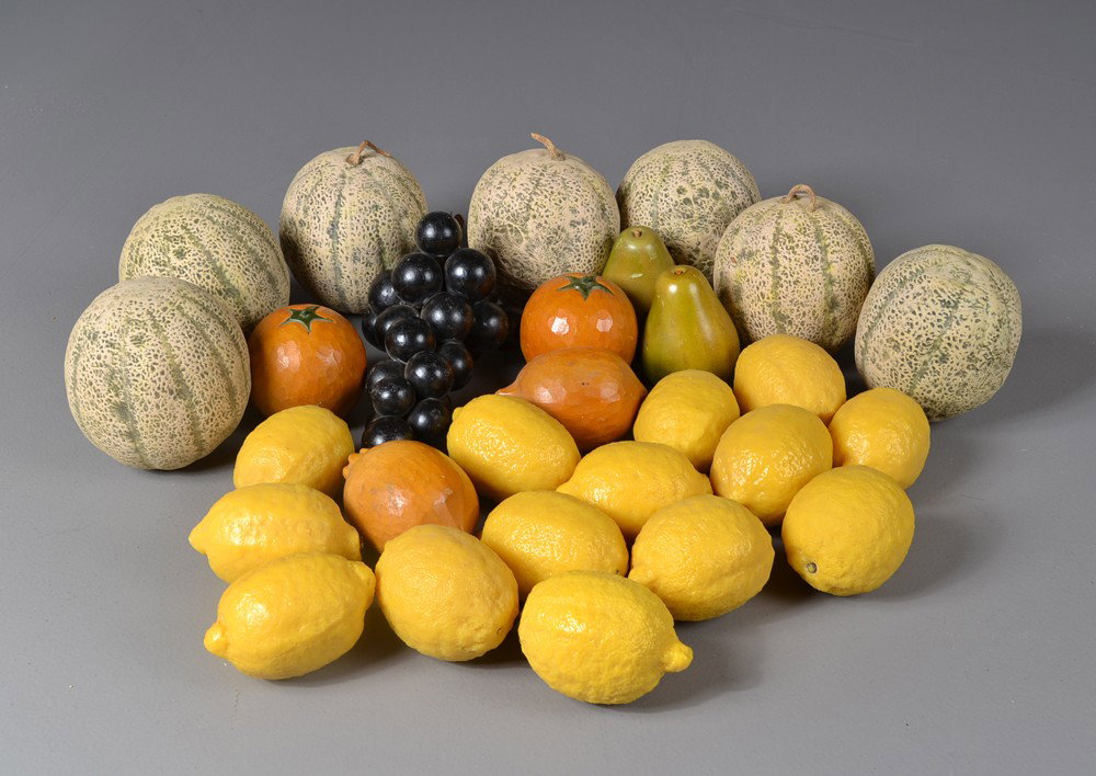 (28) Pieces of Wood and Porcelain Fruit: To include seven porcelain canteloupe, carved wood tomato, pear and grape examples, together with 14 composition lemons, longest measures 10.75". Early 20th century. Private collection Gregory, MI.
