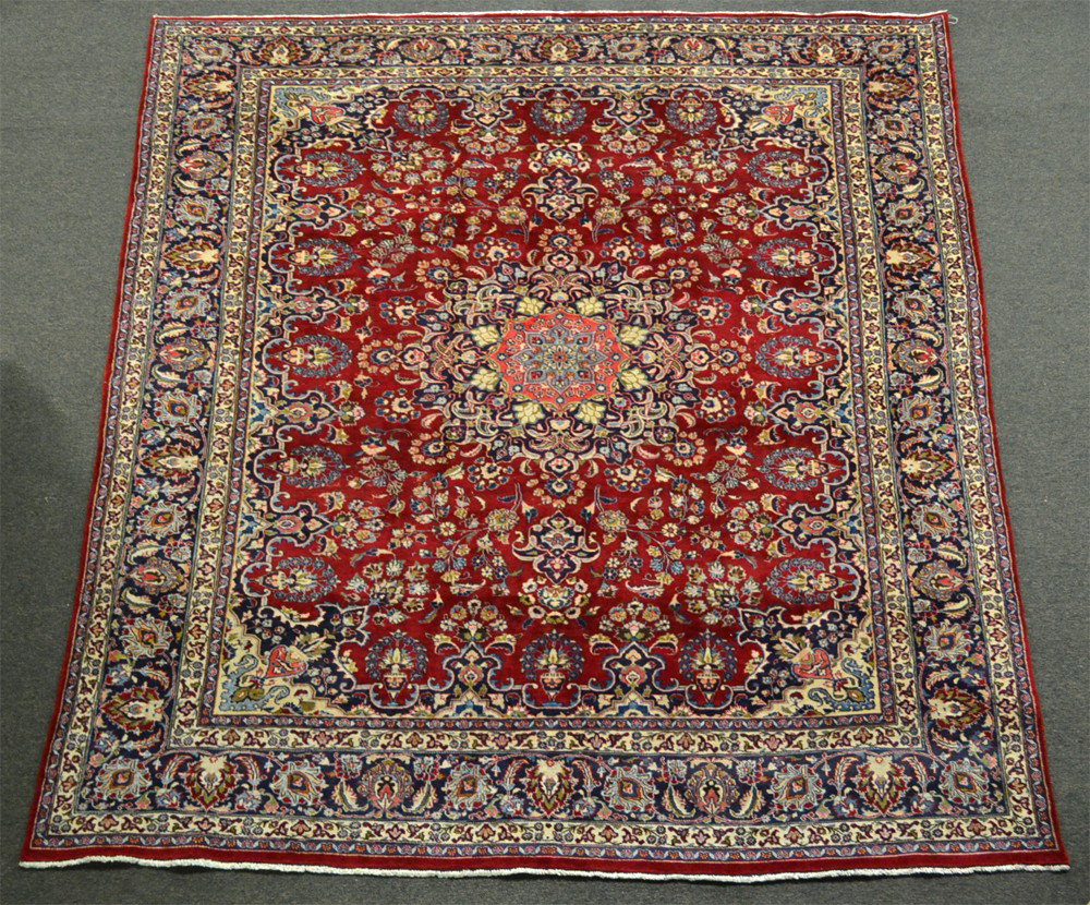 A Fine Iranian Tabriz Area Rug: Red field with central medallion floral design followed by urns of flowers and flowers to the edges, with additional colors of pink, navy, blue, mustard and cream. 13' x 9' 9". Very good condition. Ci