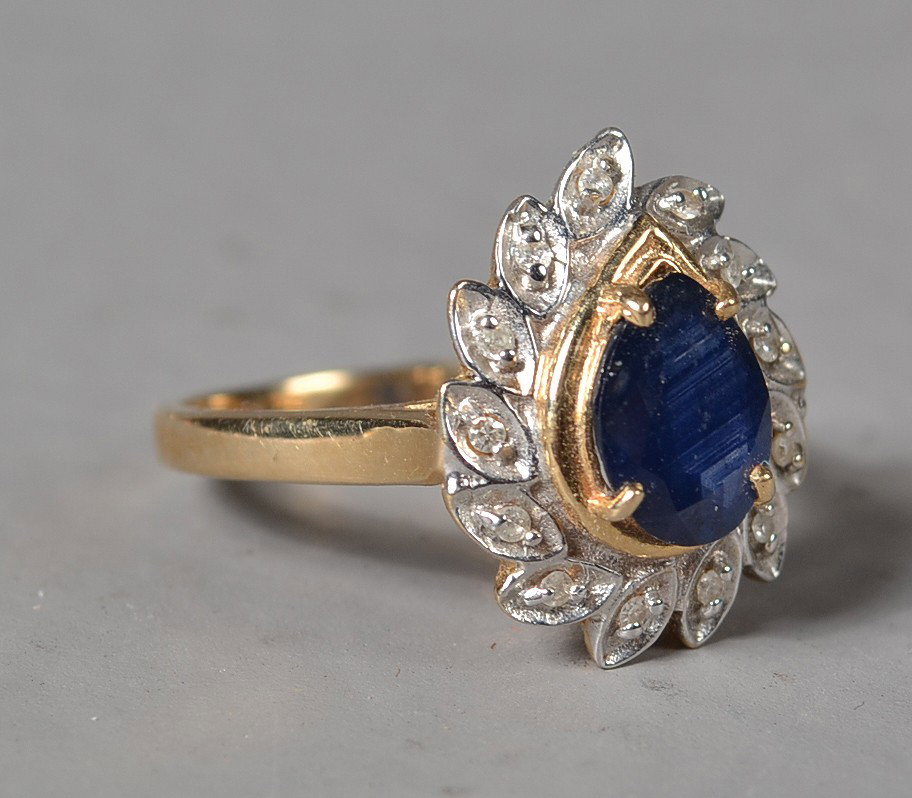 14K Gold And Sapphire Ring: A pear shaped sapphire weighing 1.4 cts, surrounded by 14 single cut diamonds weighing appr. .50 cts., size 5.75, 3 grams total weight, circa 20th century. Private collection Gregory Michigan.
