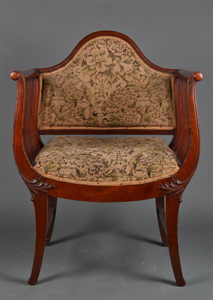An Antique Moorish Mahogany Armchair: With needlepoint seat and back, with chevron banding, with stylized foliage carvings. 32.5" H x 23.25" W x 18" D. Circa late 19th/early 20th century. Lacking one side spindle. With a wonderful old sur