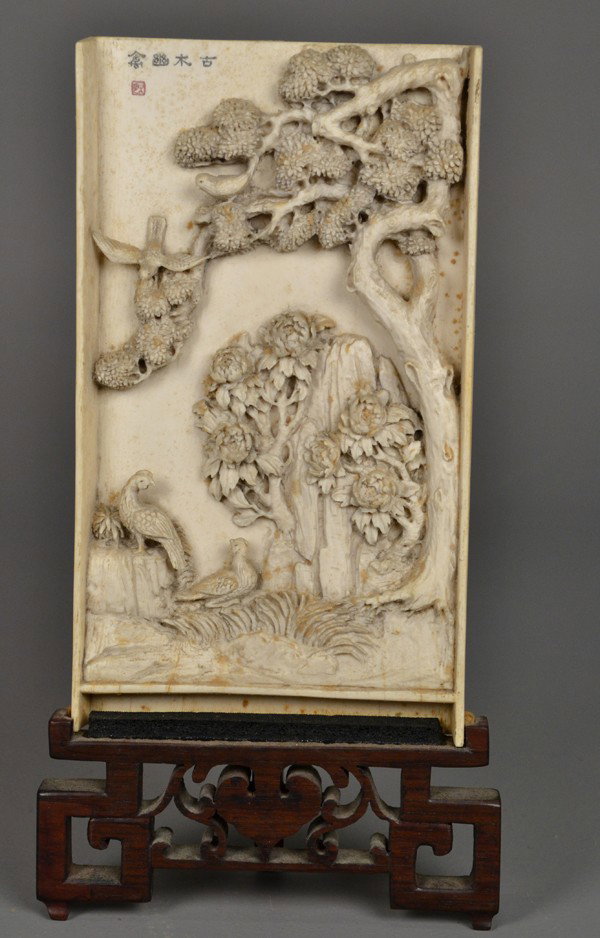 A Fine Chinese Carved Ivory Table Screen: Finely carved in three-dimensional to depict peacocks, lotus blossoms beneath an ancient pine tree, very well carved with deep undercutting inscribed in upper left with four characters in red seal mar