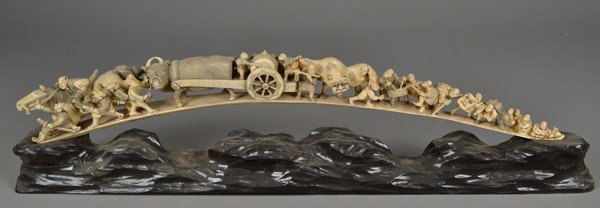 A Fine Japanese Carved Ivory Figural Grouping: Finely carved to depict a festival with horses, oxen, figures, and festival decorations, with inked and dyed elements, exquisitely rendered now mounted on a carved hardwood stand depicting mountain's,