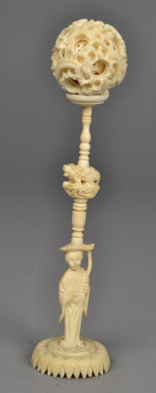 Chinese Qing Ivory Puzzle Ball On Stand: Finely carved to depict multiple layers the outside with dragons, the stand to depict standing female figure with mythical beast, measures 9.5" H,circa late 19th/early 20th century. Private collection