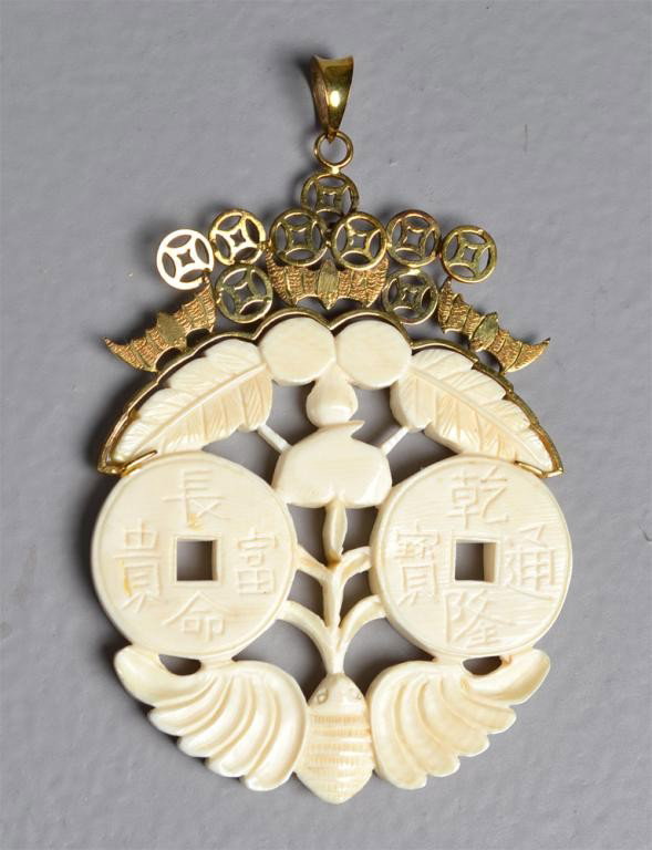 14K Gold & Ivory Pendant: The ivory finely carved to depict bi discs each side of the disc carved with charter surrounded by a bat and tobacco leafs, the 14K mounting depicting bats and symbols, 3.5"L X 2.25"W, circa early 20t