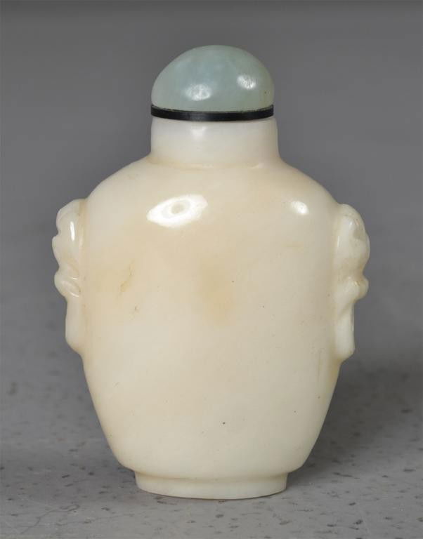 Chinese Qing White Jade Snuff Bottle: The body left uncarved but finely polished, the stone a white to very light celadon, with two masked rings, with celadon jade stopper, 2.5"H, circa 20th century.