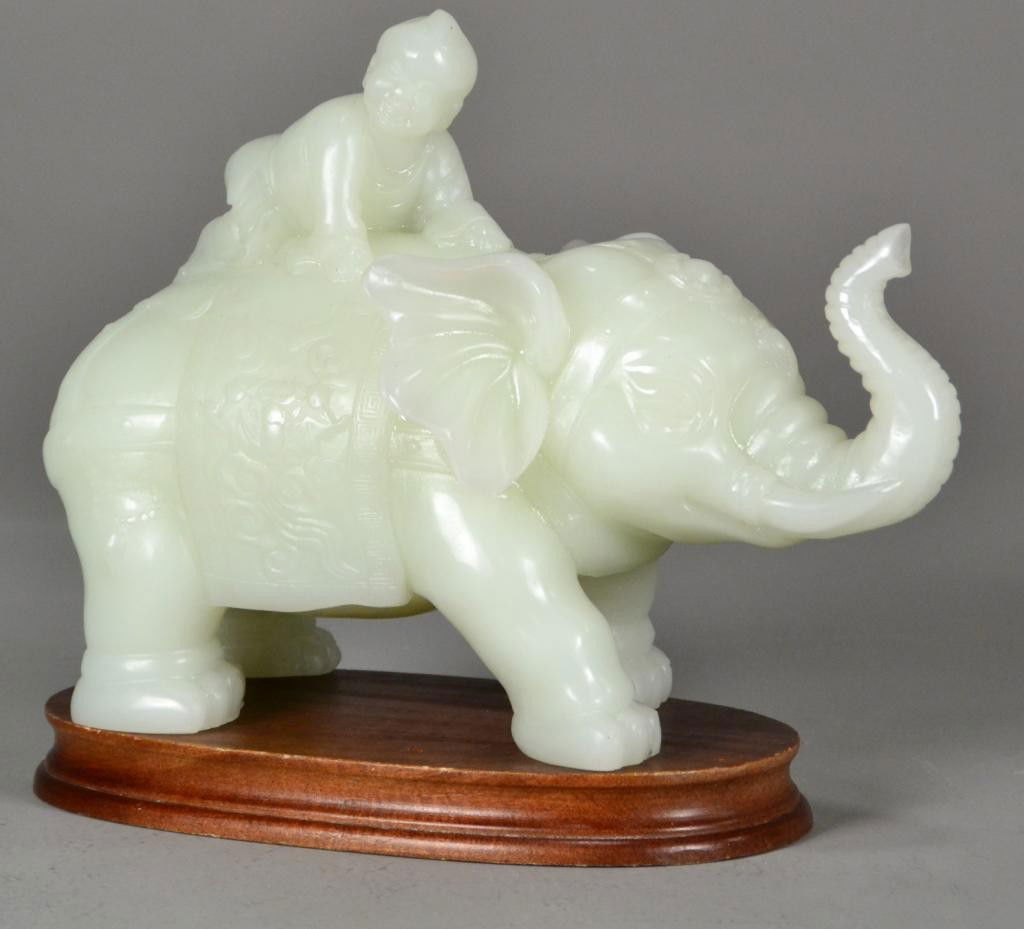 Chinese Qing Carved White Jade Elephant Group: Finely carved to depict a saddled elephant with boy atop his back, with raised trunk, in jeweled forehead, the stone a white to light celadon with fine polish, 10"W X 7.5"H, circa late 19th/early 20th