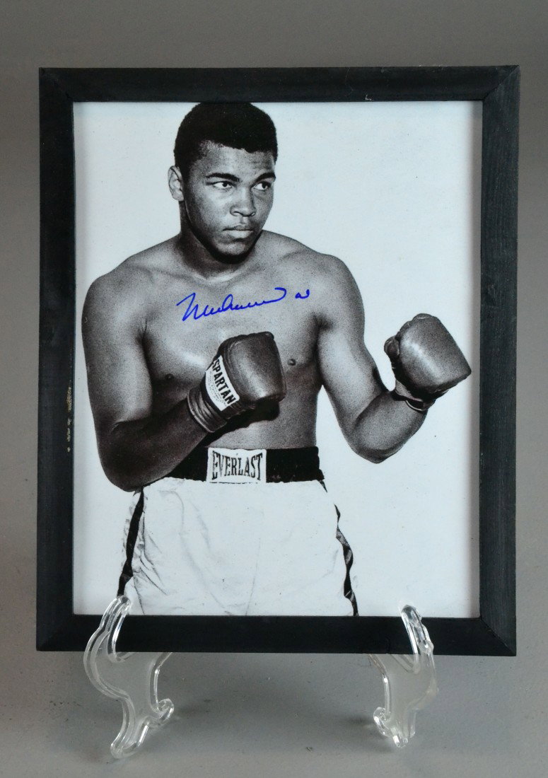 MUHAMMED ALI AUTOGRAPHED PHOTO - IN GLOVES: Autographed black and white photo of Mohammed Ali striking a boxing pose wearing Spartan boxing gloves and Ever last trunks, 8" x 10" framed, with certificate of authenticity. Private collection Marga