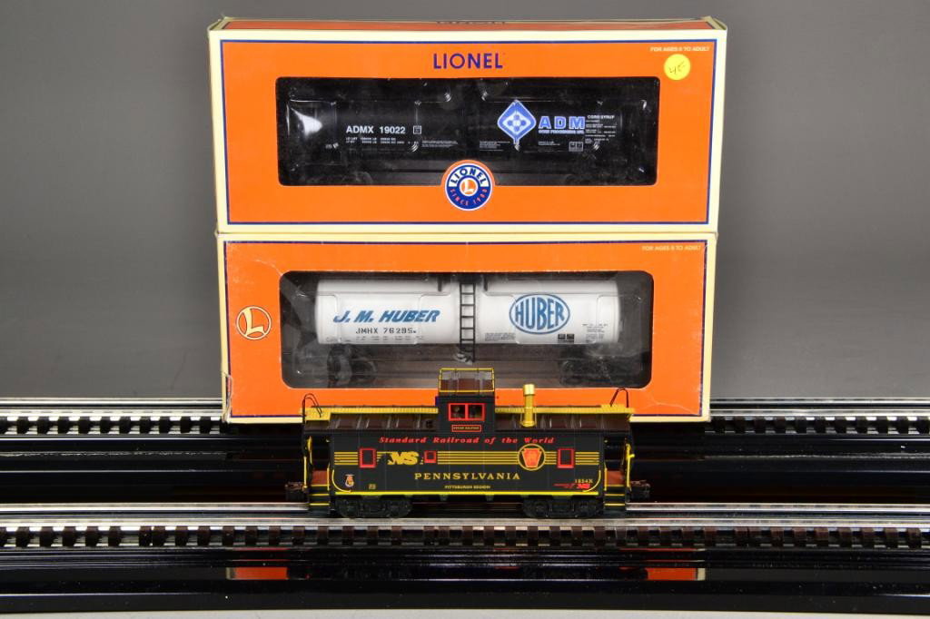 (3) LIONEL ELECTRIC TRAIN CARS: Including three Lionel train cars: ADM unibody black ADM corn syrup tank car #19022, 6-17953, 11" L, J.M. Huber white tank car, #19022, 6-17913, 11" L, PRR Heritage CA-4 black with red and gold trim, 