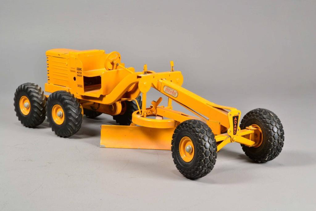 MODEL TOY MOTOR GRADER: An 'Adams Motor Grader, Diesel' by Charles Van Doepke Mfg. Co., painted construction yellow/orange with thick rubber tires, 26" L, 9" W, 8" H, circa 1950, very good condition, no rust. Private collect