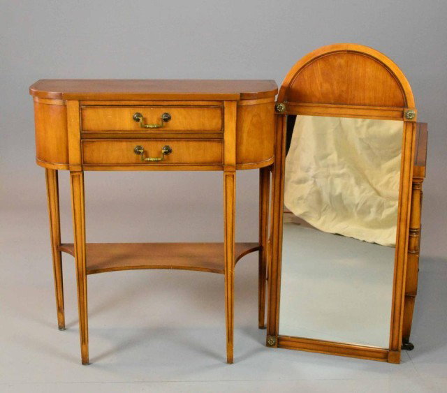 A PECAN HALL TABLE AND MATCHING MIRROR: To include a black banded notched top, above two dovetail drawers, with single shaped shelf below, and raised on tapered legs, along with a matching arched mirror with brass rosettes, table 32" H x 28