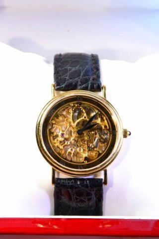 CROTON MEN'S 18 K GOLD WRISTWATCH: Fascinating skeleton movement front and back so as to view gears, jewels and movements, water resistant Swiss made, Roman numerals on face, 18 karat gold case and crown, genuine crocodile band, like n
