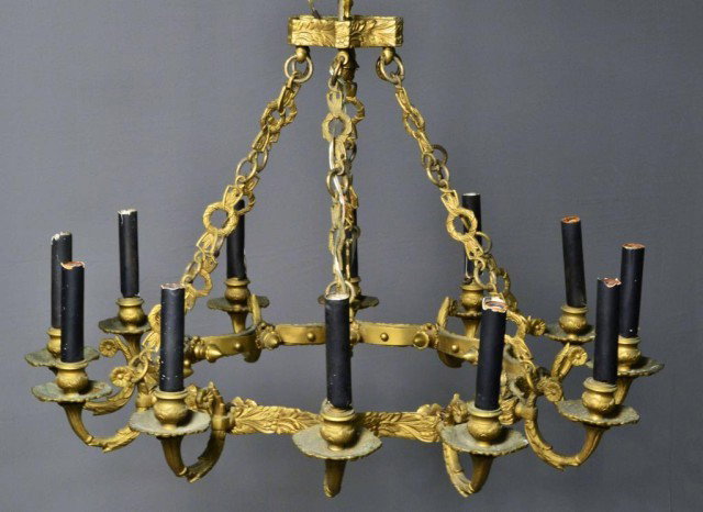 BRONZE ART NOVEAU 12 LIGHT CHANDELIER: Electrified Turn of the Century bronze Art Noveau 12-light chandelier, base 26" in diameter, 20" suspension length; chain of wreath & dart design, acanthus leave/tudor rose decoration and acorn drop f