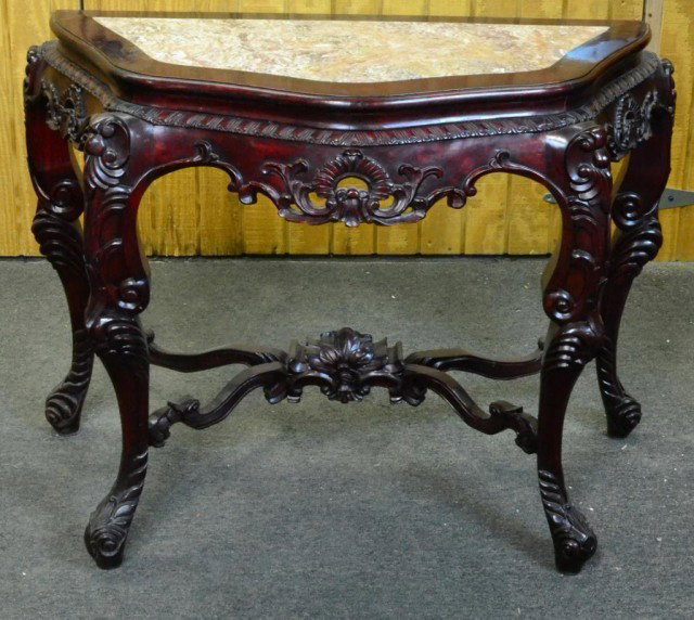 CHINESE HALL TABLE WITH INSET MARBLE TOP: Very nice rosewood hall table with curvelinear molded front, legs heavily carved with leaf and scroll design, x-stretcher similarly carved with large floral design in denter, pink marble inset into to
