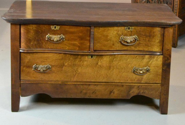 CARVED THREE DRAWER MAHOGONY WASH STAND: A Victorian era carved mahogony wash stand, paneled sides, with two curved drawers on top, one long drawer on bottom. All three drawers dovetailed, with escutcheon with key holes, and pulls, 23.5" H x