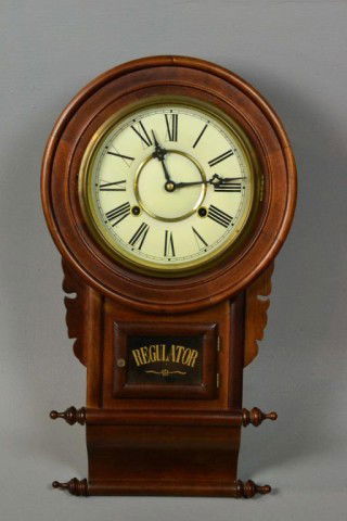 Regulator Hanging Wall Clock: Having scroll design, with Roman Numerals on the face, clock comes with key, small glass door on the front allows for storage and access for maintiance, clock is 22" L X 12"W, circa 20th century. Priv