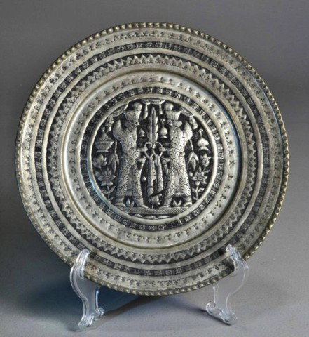 Heraldic embossed tin plate w/ winged figures & snakes.: Achaemenian Persepolis Style Hammered chased design on rim. 12" in diameter.