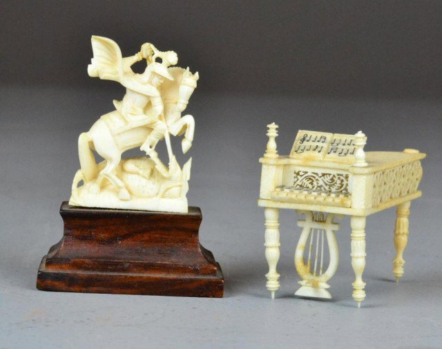 (2) Bone Carvings Including Piano And Soldier: To include a intricately carved piano with music sheet and St. George and the dragon. Circa late 19th/early 20th century. Tallest measures 3" H. One partial wheel carving missing on piano. Private col