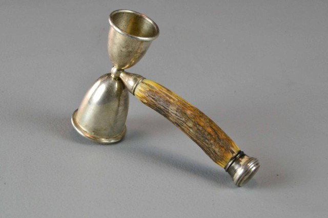 A STERLING AND STAG HANDELED JIGGER: Stamped sterling with one further hallmark illegibel, both the cups and pommel are both sterling, 6.25" L X 4.25" W, circa 20th century.