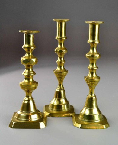 (3)ENGLISH PUSHUP CANDLESTICKS 19TH C: Matching pair of English brass turned push-up candlesticks 9" H with square base 3.25" base, along with similar 8.75" H candlestick, circa 19th century, good condition. Private collection Bloomfield H