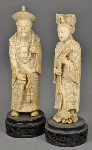 Pair Of Chinese Carved Ivory Figures: Finely carved to depict an emperor and empress him holding a sword, her a ruyi scepter, both on carved hardwood stand, measures 7.75" H including stand. Circa early 20th century. Private collection Ox