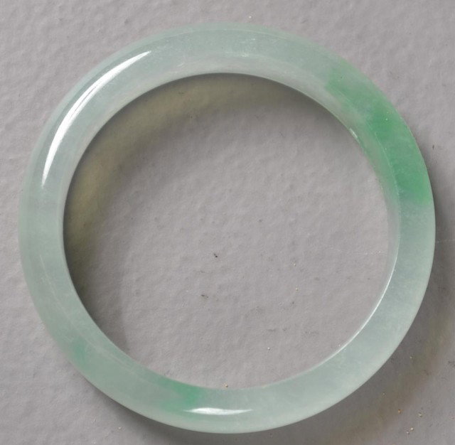 Chinese Carved Jade Bangle Bracelet: Hand carved jade bangle bracelet, beautiful translucent celedon mottled jade, measures 2.75"D.