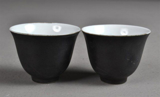 Pair of Chinese Monochrome Tea Cups: Small pair of white porcelain cups, exterior glazed with black, interior has delicate sumi painting with carp and tree, 2" H. Private collection