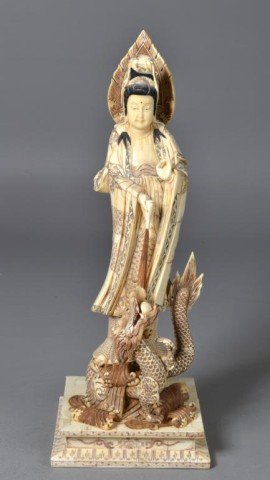 A Massive Chinese Carved Ox Bone Guan Yin: Finely carved to depict a standing guanyin with head piece with dragon in three dimensional carved on stand with additional embellishments, she is holding a vase pouring something on the dragon, the d