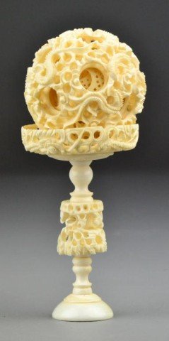 Chinese Carved Ivory Puzzle Ball On Stand: The stand base finely carved to depict dragons, body of the stand carved to depict villigers under an ancient tree, the ball depicting dragons having many layers, 6.75"H overall, circa early 20th cent