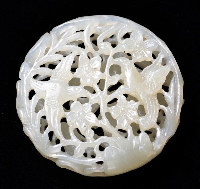 Fine Chinese Carved Jade Pomander: Intricatly carved with open work, one side to depict birds amongst lotus blossoms, the reverse to depict a deer eatting, the stone a white to light celedon color, 2"D, circa early 20th century.