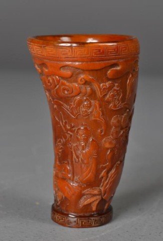 Chinese Carved Horn Cup - Figural & Landscape: Finely carved and polished horn cup depicting figures, deer, bats and trees, Greek Key decoration to rim and base, 4.25" H x 2.5" Diameter.