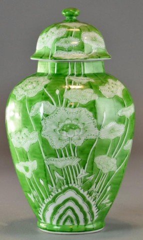 A Chinese Covered Ginger Jar: Eight sided ginger jar with green ground and decorated in white lotus flowers and tendrils. 15" H, circa 20th century. Good condition.