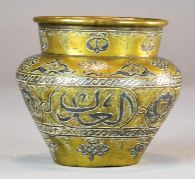 An Islamic Inlaid Brass And Copper Jar: With dovetailed foot rim, and rolled rim, inlaid with silver or pewter to depict various designs and Islamic text, measures 4.875"H X 5.5"W, circa 19th century. Private collection Lake Orion MI.