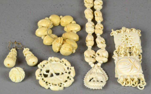 (7) Pieces Chinese Ivory Carved Jewelry: To include a bracelet with loose rings and carved placques, a necklace with finely carved elephant beads hung with elephant placque, a bracelet with carved scarabs, a broach depicting a herd of elepha