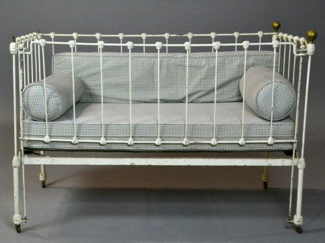 An American Childs Cast Iron Crib: Designed to resemble a cast iron yard fence with cast iron casters and ball form brass finials, 53" W x 34" H, circa early 20th century. Condition lacking two brass finials.