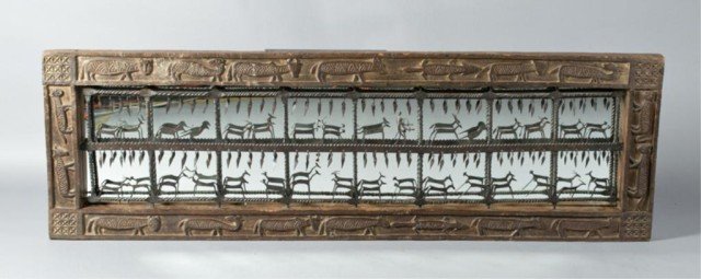 A Very Fine African Wood and Mounted Iron Mirror: A large African mirror with central hand wrought iron sculpture depicting animals and hanging tassels, framed in carved wood depicting animals with inset mirror behind ironwork. With mortise & tenon c
