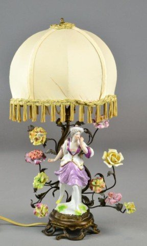 A Fine French Porcelain & Bronze Boudoir Lamp: In the Rococo manner, finely moulded in the form of a tree with hand painted porcelain rosettes, and a large porcelain figure of a beauty, with silk shade hung with tassles, 17" H, circa late 19th cen