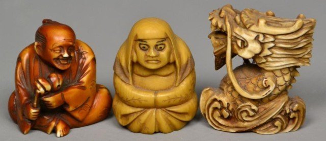 (3)Japanese Carved Ivory Netsuke: Probably Meji period, finely carved, one to depict seated man, one seated woman, and one dragon head, all with character mark except dragon, tea stained with inked and dyed elements, tallest is 2" H. 