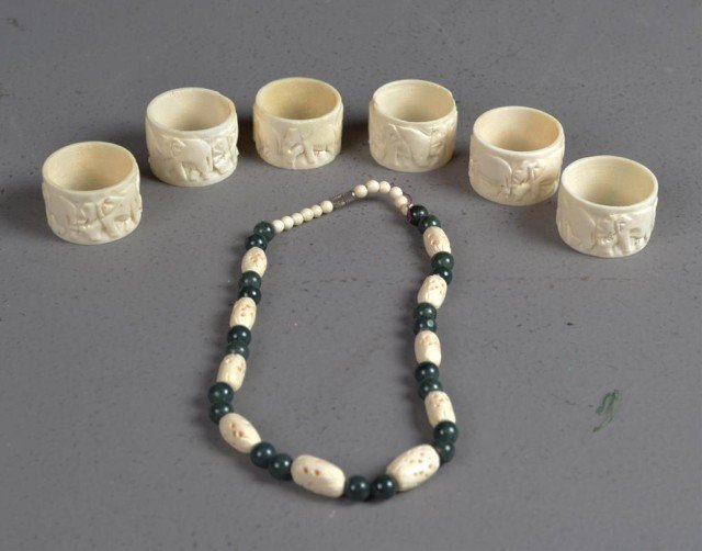 (6)Bone Napkin Rings& (1)Bone Necklace: Napkin rings finely carved to depict elephants on the march, each measures 1.25"D, the necklace with jasper beads measures 16"L. Private collection Oxford MI.