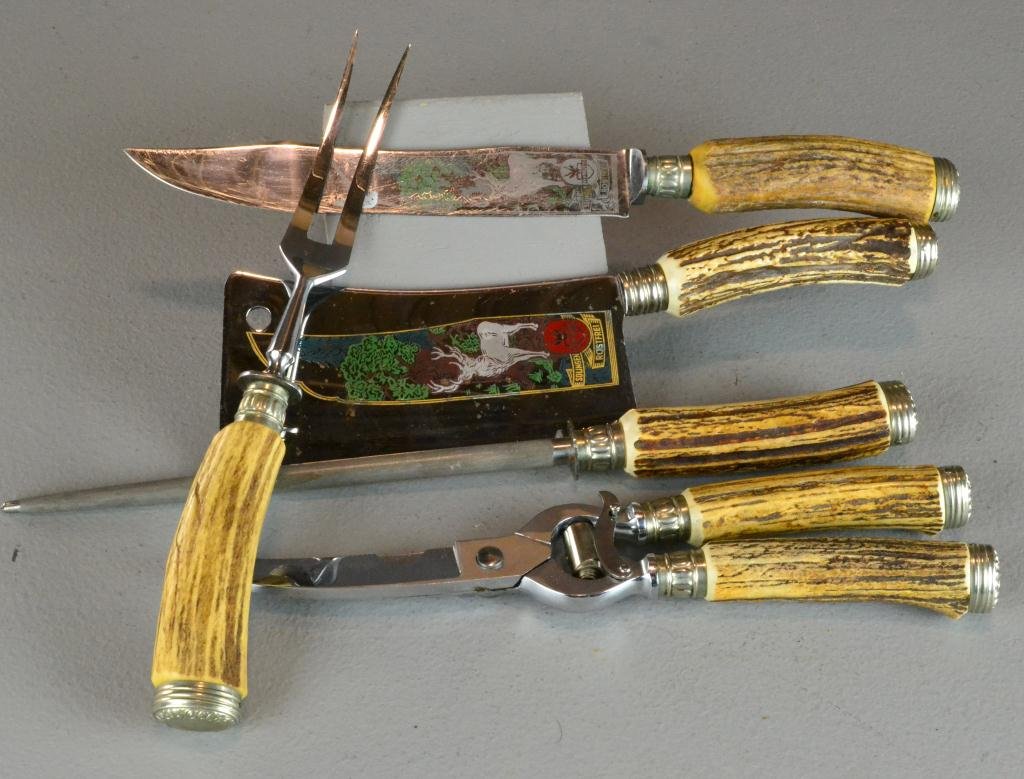 (5) Pcs. Solingen Stell and Antler Carving Set: To include a cleaver, carving knive, poultry shears, large fork and a sharpener, all with stag handles, marked Rostfrei Solingen Rehwappen, larges is 14", excellent condition. Private collection Colum