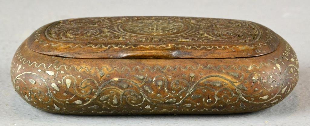 Islamic Olive Wood Box Inlaid with Silver: Small oval wooden hinged box with carved scrollwork on top, inlaid silver on top, sides and bottom, marked 1917, 1.25" H x 4.25" L x 3" W, good condition. Private collection Warren, MI.