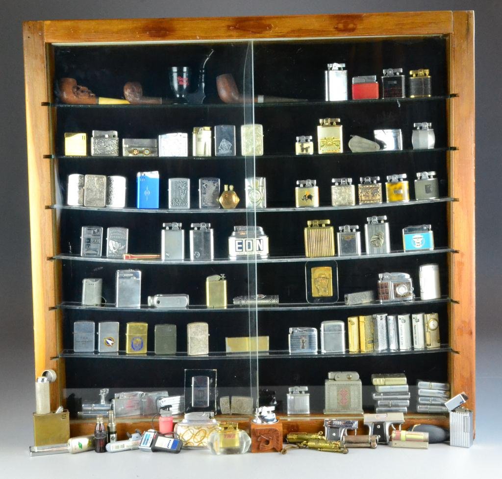 A Large Collection of over 260 Lighters & Display: To include zippo and many more figurative and unique examples with hanging display case having sliding glass doors, circa early to mid 20th century, along with well-constructed wood case with six 2" d