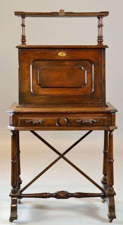 Eastlake Walnut Drop-Leaf Secretary with Key: Elegant recessed panel drop-leaf desk with oval brass escutcheon and key, opening to reveal seven pigeon holes and one small drawer, one ornately carved drawer above reeded and turned legs, with brack